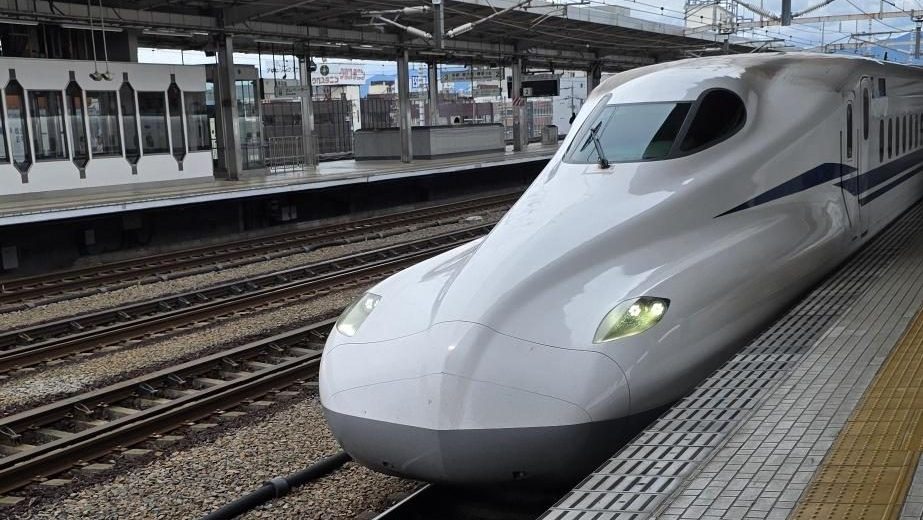 Ein Shinkansen-Hochgeschwindigkeitszug fährt in einen Bahnhof in Japan ein und symbolisiert Mobilität, Vernetzung sowie das Leben und Arbeiten in Japan.
