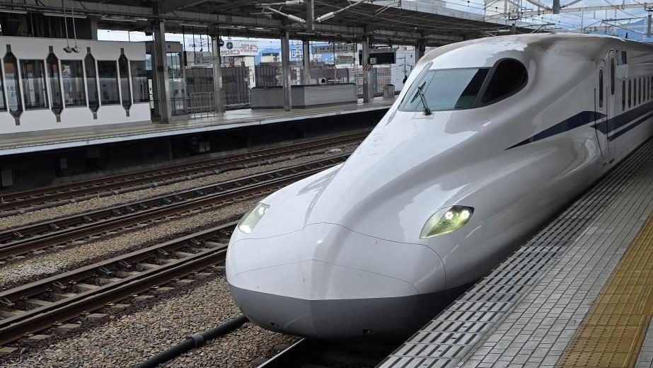 日本の駅に到着する新幹線。移動の利便性、人と人とのつながり、そして日本での暮らしと仕事を象徴する風景。